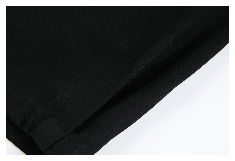 Close-up of the smooth black trouser fabric and stitched hem edge.