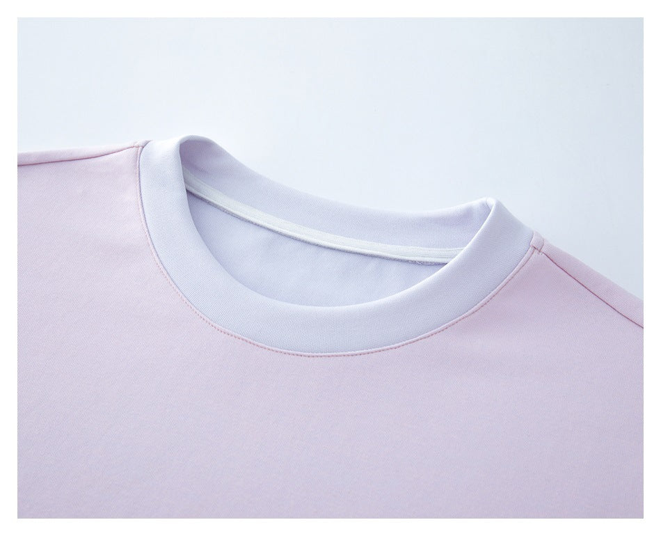 Close-up of a pale pink T-shirt's light-colored ribbed crew neck and shoulder seams.