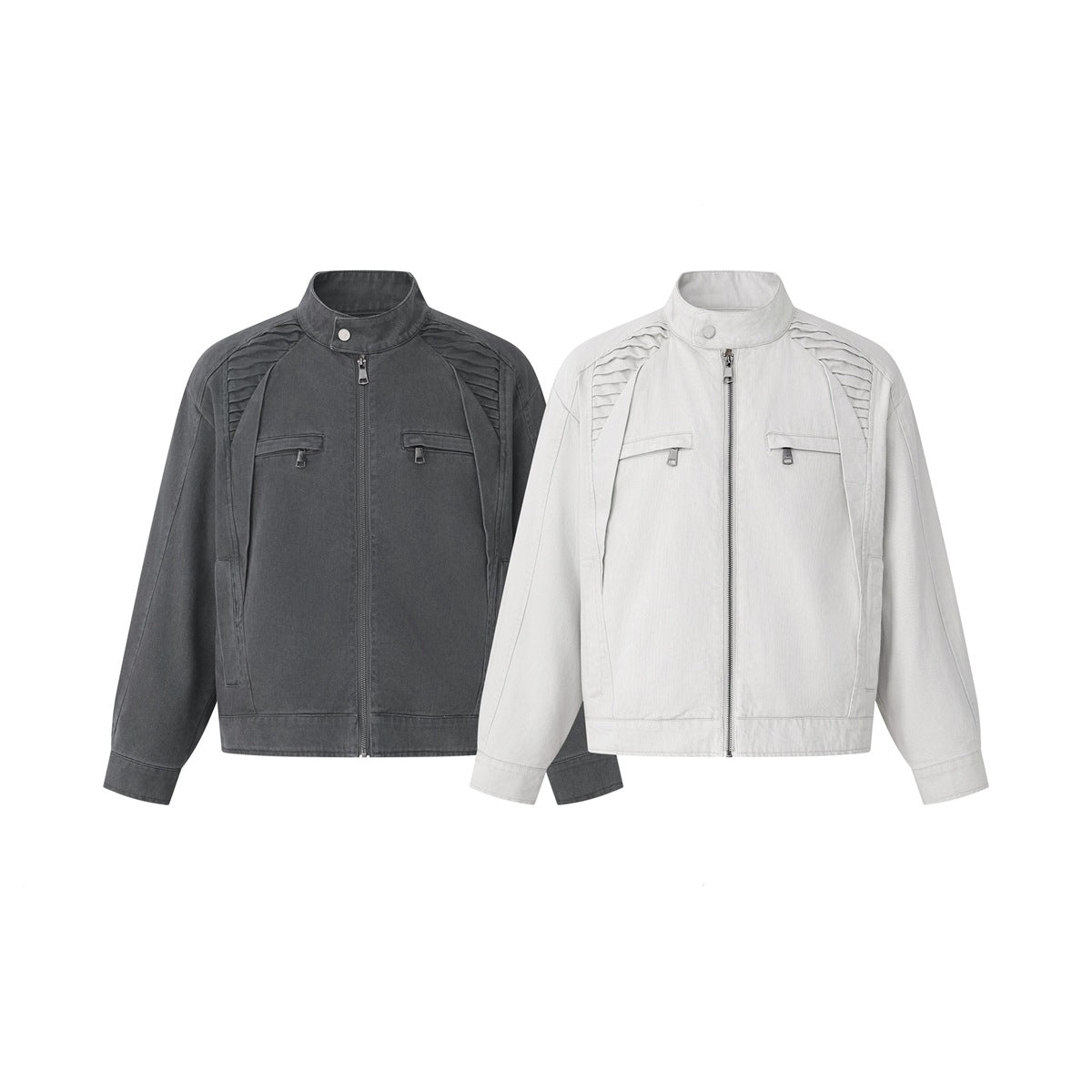 Front view of two zip-front jackets in charcoal gray and off-white, with stand collars and pleated shoulders.