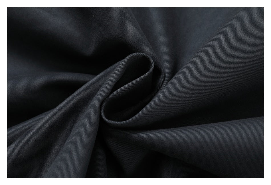 Close-up of smooth black fabric folded into soft curves, showing a fine diagonal weave.