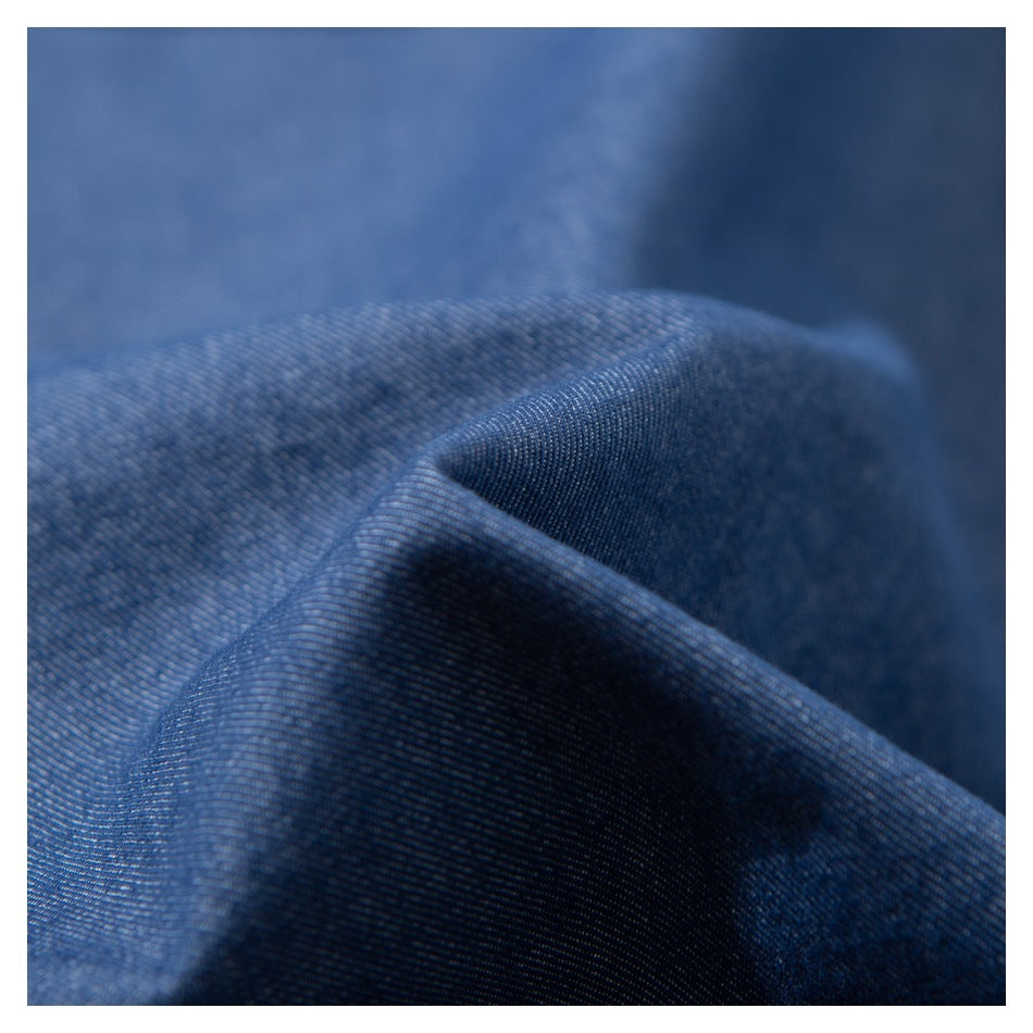 Macro view of the blue fabric's woven surface and folds.