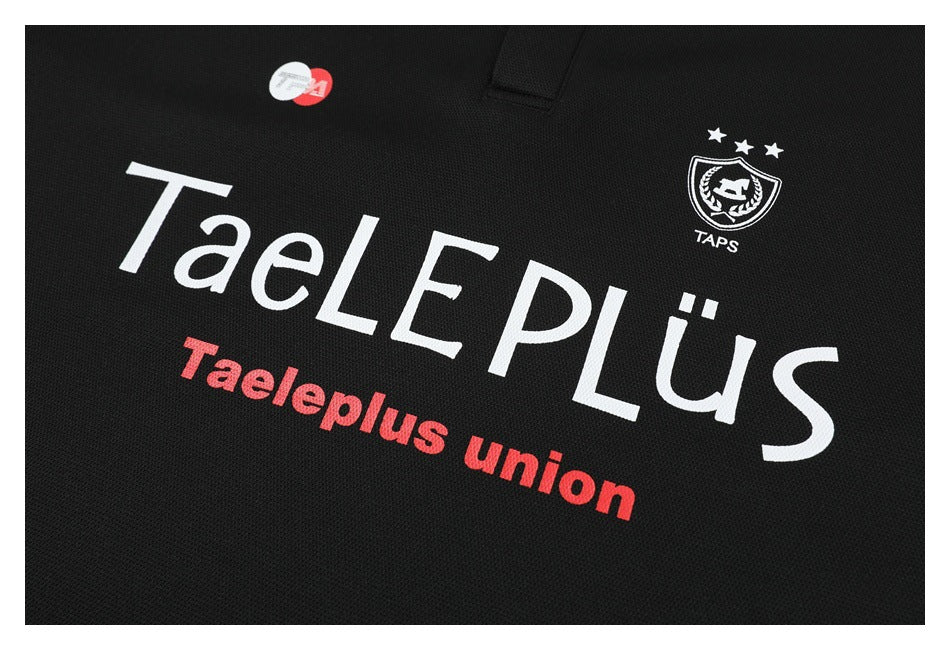 Close-up of a black shirt with large white and red TaelPlus Union lettering and a small crest.