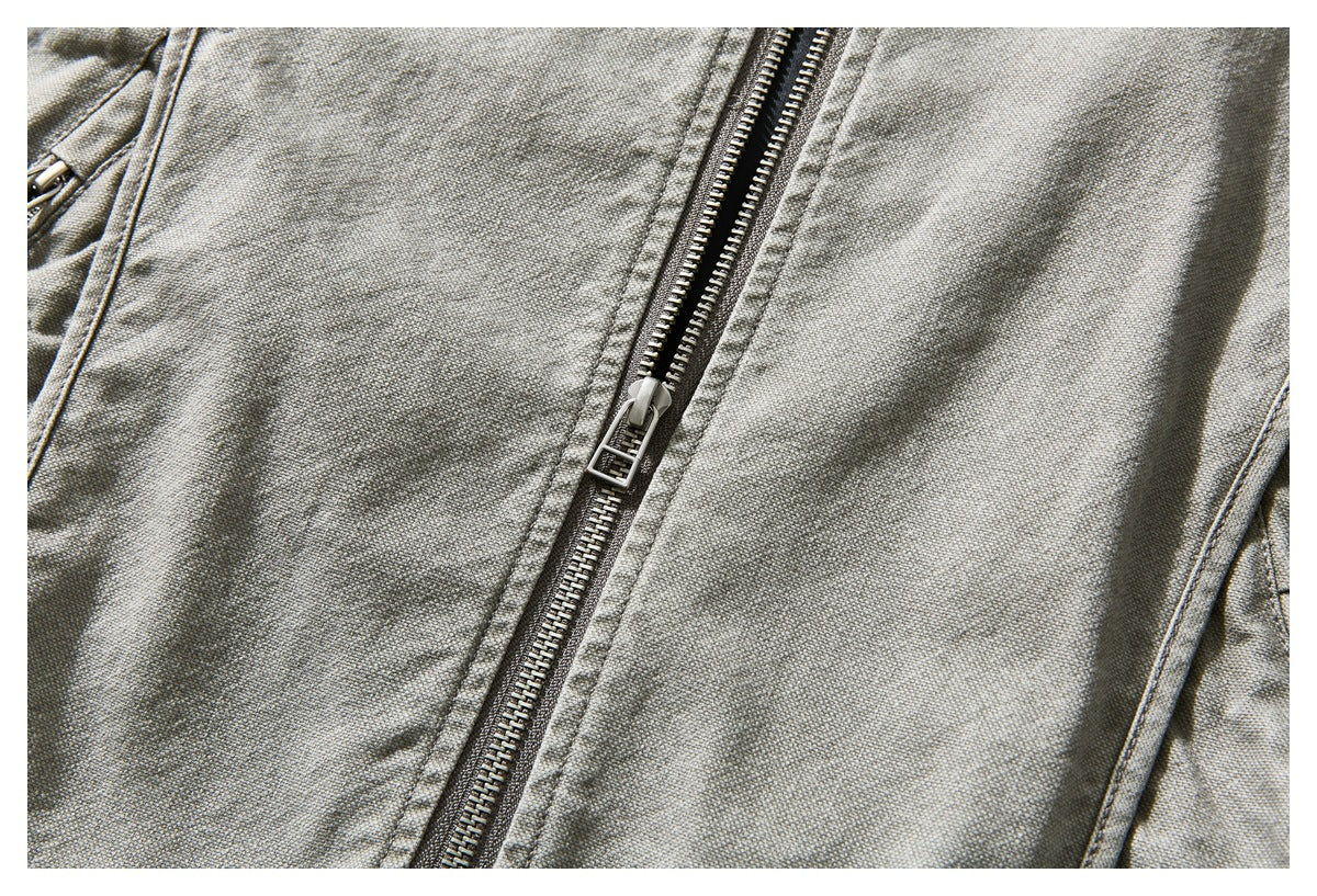 Close-up of the gray washed jacket's central metal zipper and textured fabric.