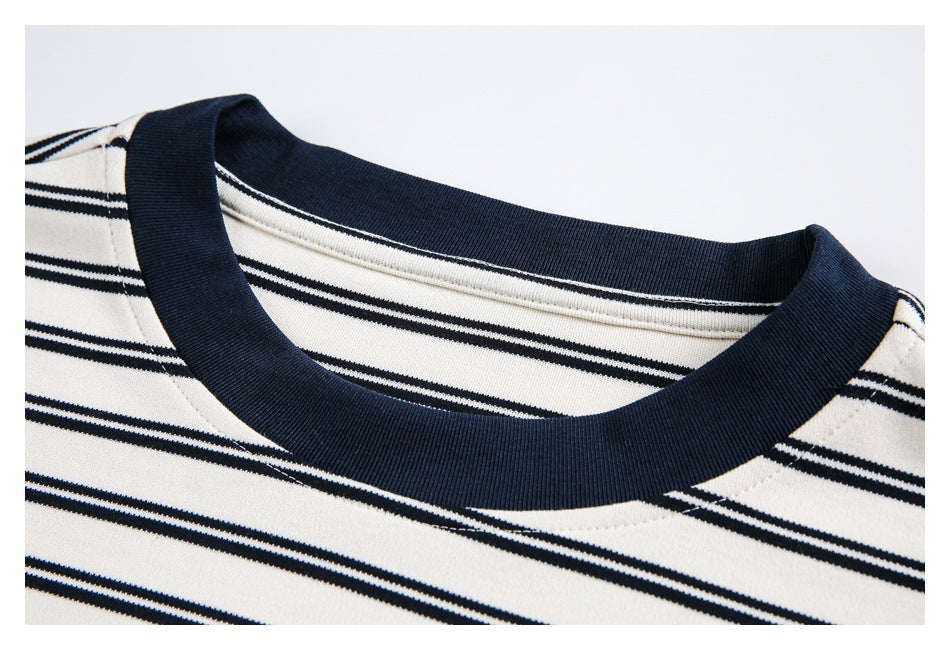 Close-up of a navy ribbed crew neck on a white shirt with thin navy stripes.