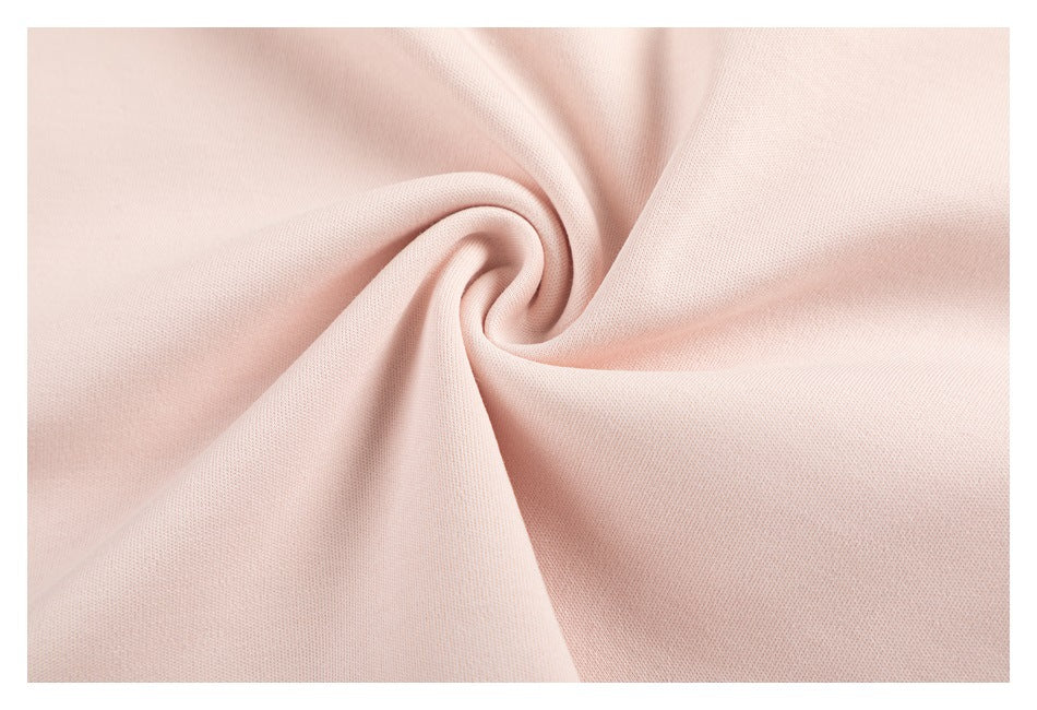 Close-up of pale pink fabric gathered into a swirl, showing its surface texture.