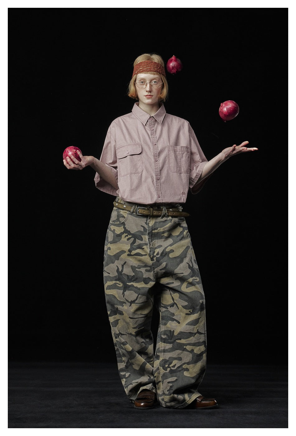Full-length model wearing a dusty pink short-sleeve shirt and wide-leg camouflage pants.