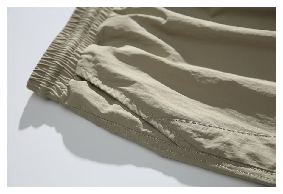 Close-up of beige jogger pants showing the elastic ankle cuff, stitched seams and fabric folds.