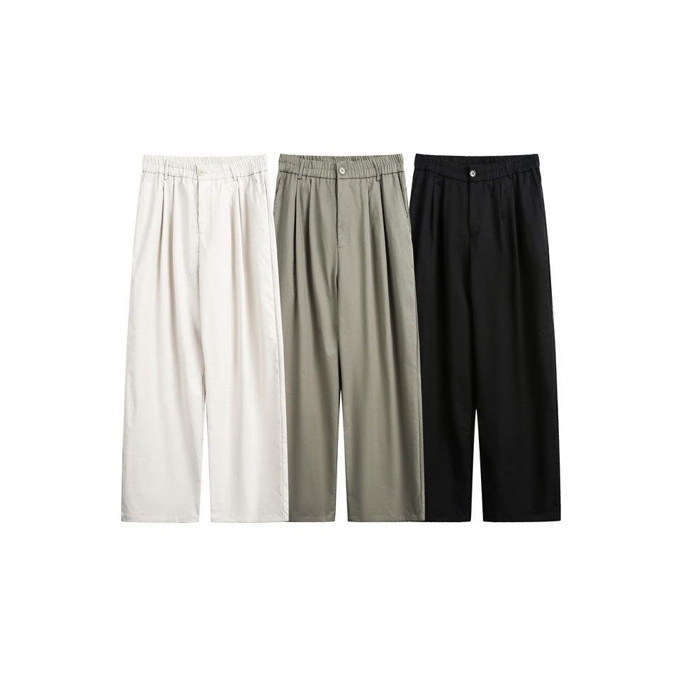 Three pairs of loose wide-leg trousers shown together in ivory, muted gray-green, and black.