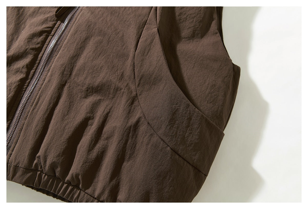 Close view of the brown jacket's side seam, curved panel and gathered lower edge.