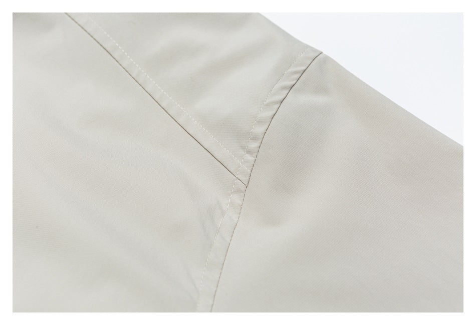 Close-up of stitched seams joining panels on a light beige garment.