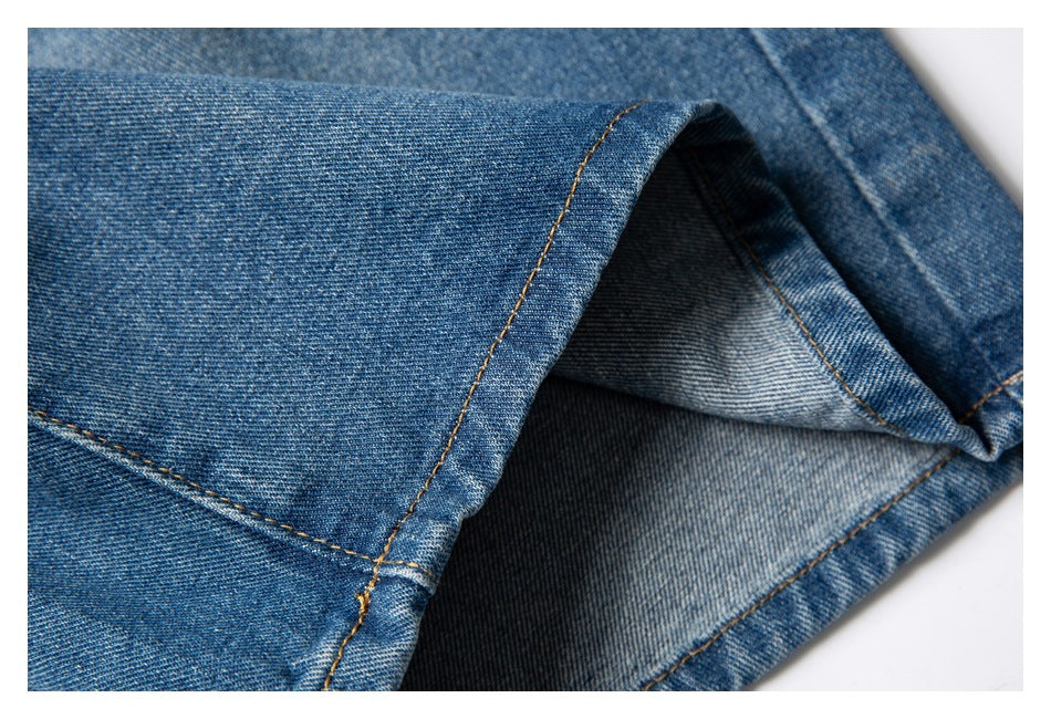 Close-up of a blue denim shorts leg opening, showing the hem stitching and inside of the fabric.