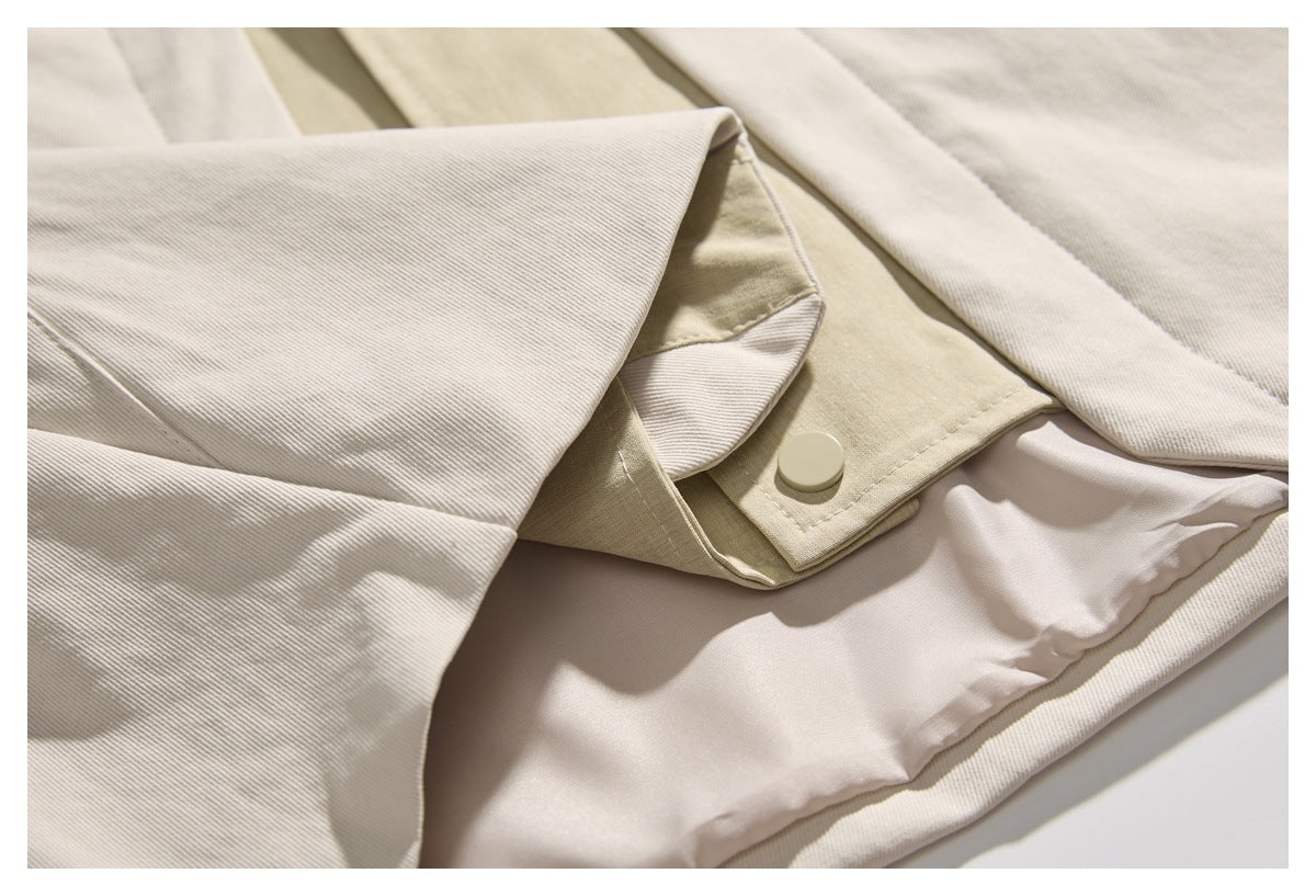 Close-up of the cream jacket's beige snap-fastened panel and pale inner lining.