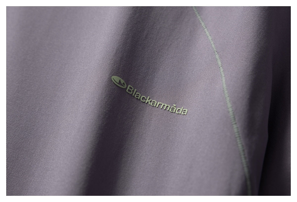 Close-up of a small Blackarmada logo on the purple jacket fabric.