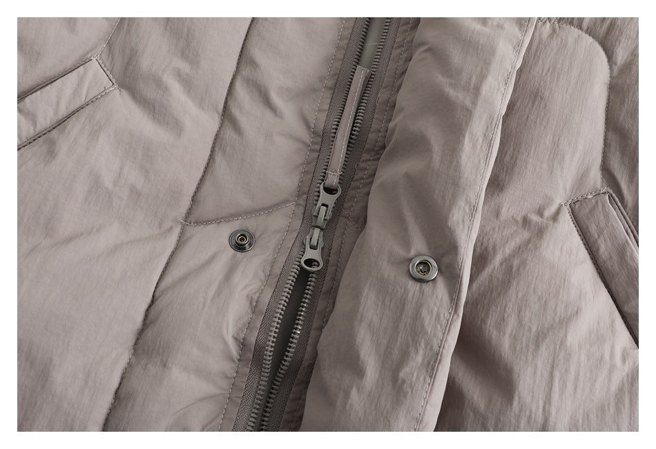 Close-up of the taupe padded jacket's zipper, snap fasteners and stitched front placket.