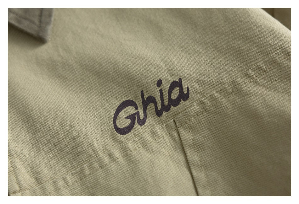 Close-up of a dark cursive logo printed on beige garment fabric.