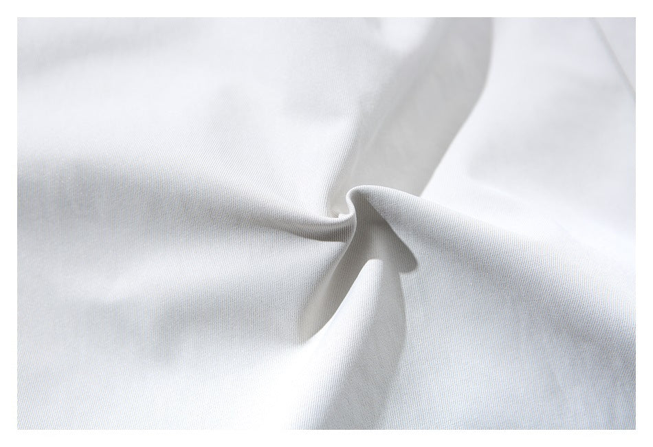 Close-up of pale gray trouser fabric gathered to show its drape and surface texture.