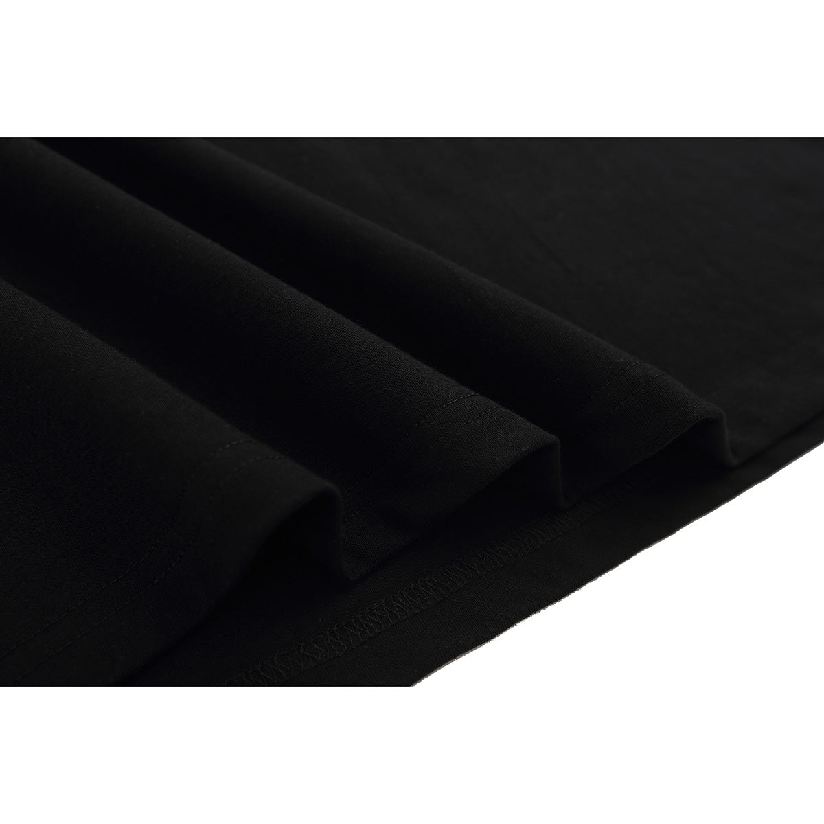Close-up of the black T-shirt's folded fabric and stitched hem.