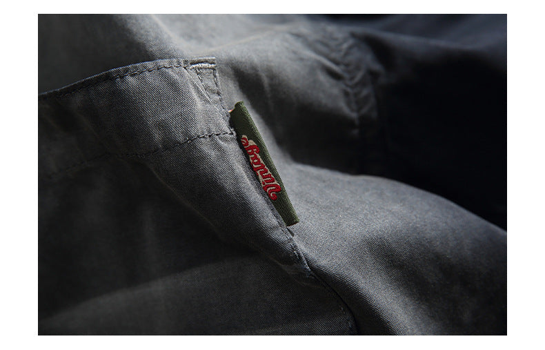 Close-up of a dark garment pocket with a small red script label at the edge.