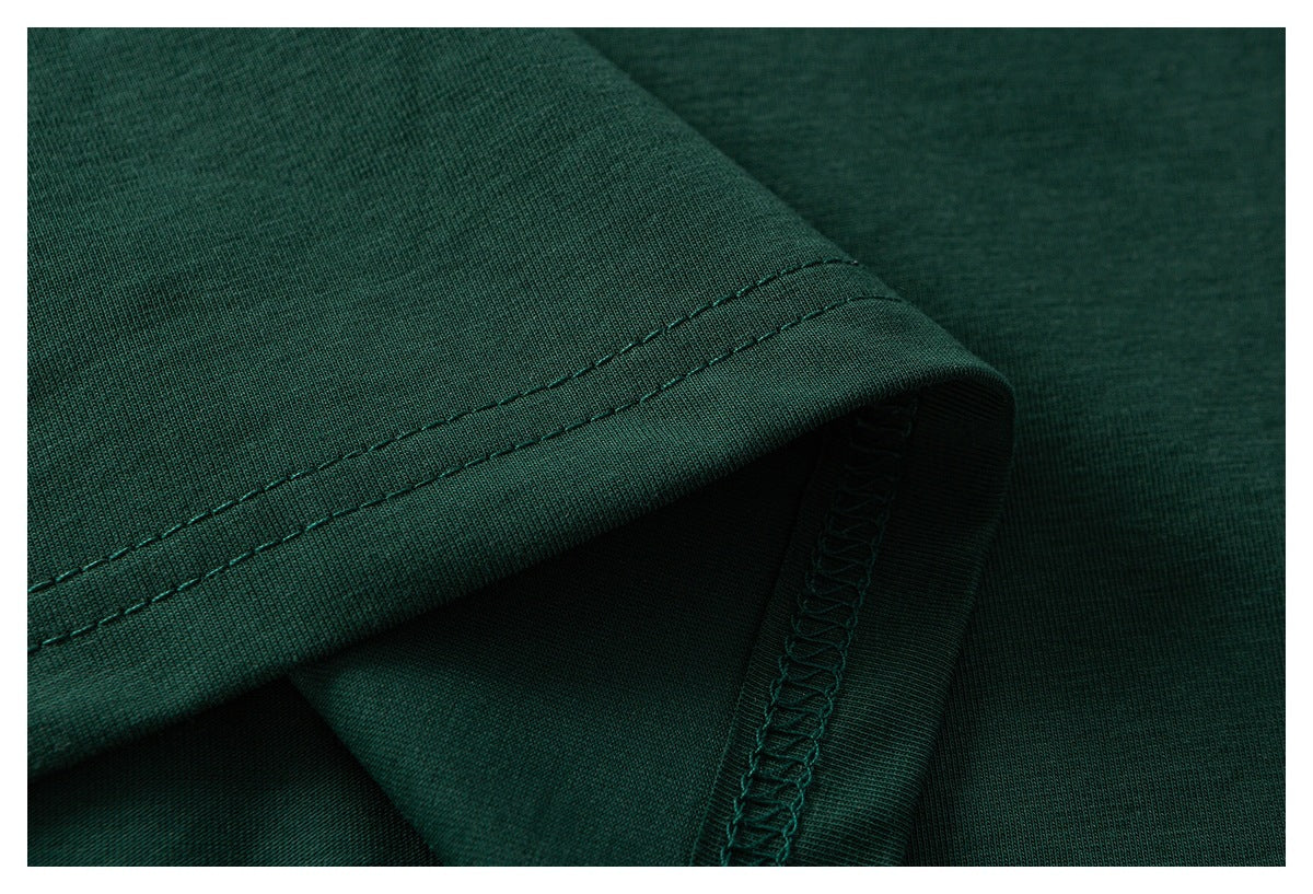 Close-up of a dark green shirt hem with double stitching and an overlocked seam.
