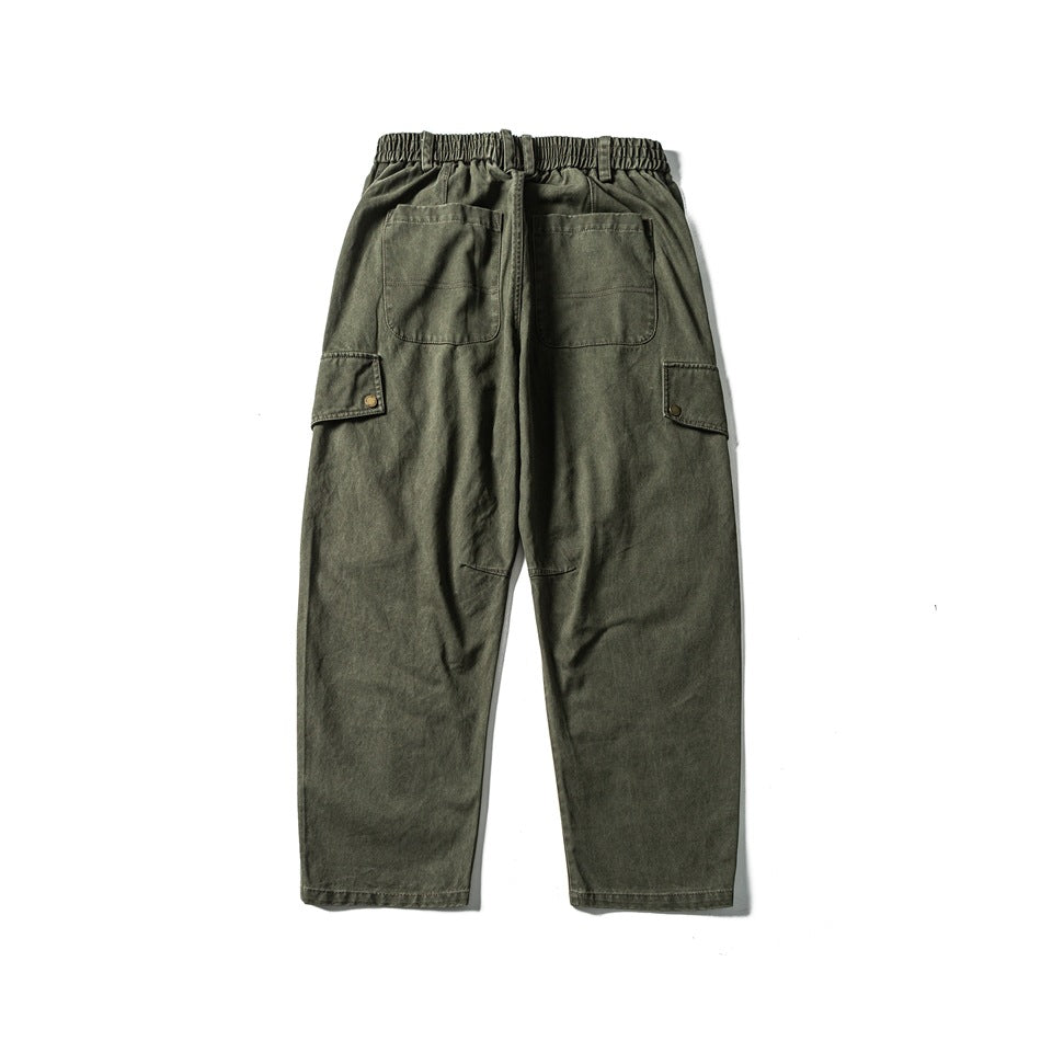 Back view of olive cargo pants with an elastic waistband, two rear pockets and side flap pockets.