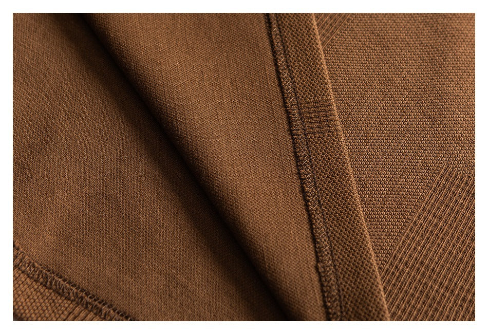 Close-up of brown knit garment fabric with stitched seams and a folded edge.