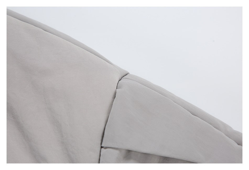 Close-up of a light gray jacket shoulder seam and sleeve panel.