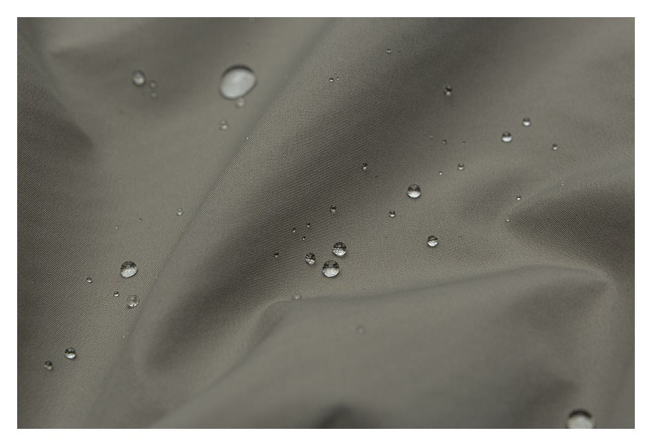 Water droplets bead on a close-up of gray-olive woven fabric.