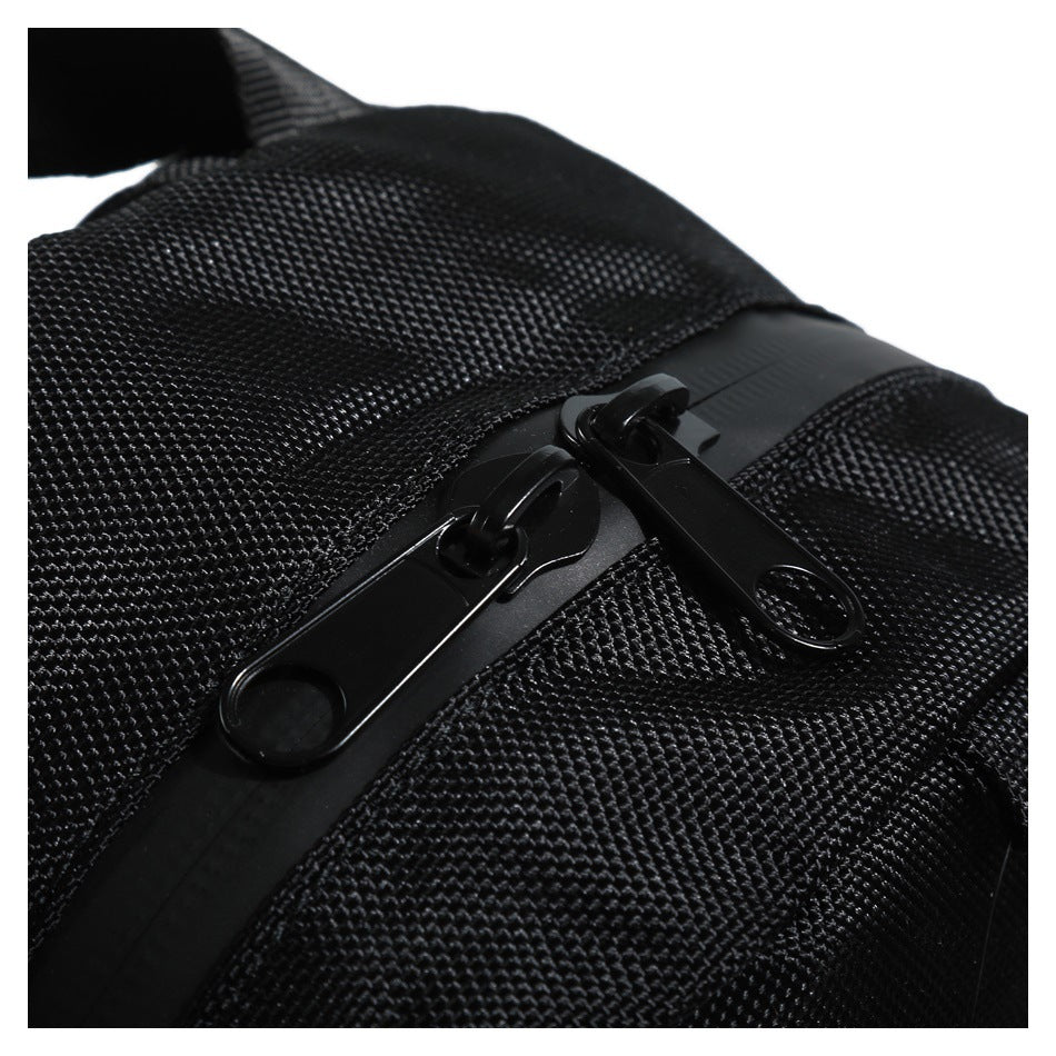 Close-up of two black zipper pulls on the textured fabric of a black backpack.