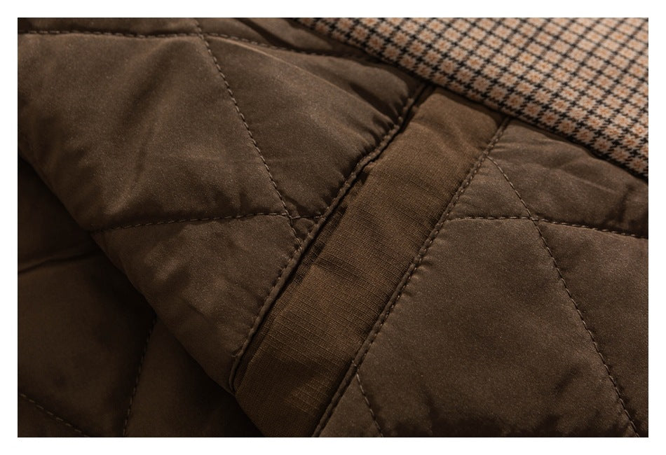 Close-up of brown quilted fabric and a stitched band, with checked fabric visible behind it.