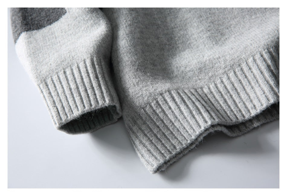 Close-up of a light gray sweater sleeve cuff beside its ribbed hem.