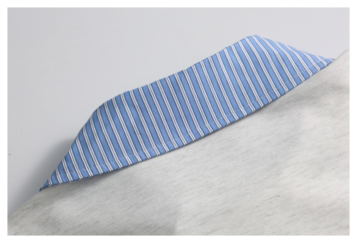 Close-up of a blue-and-white striped collar or trim against light gray fabric.