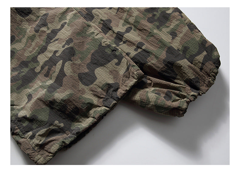 Close-up of a gathered edge on olive, brown and black camouflage fabric.