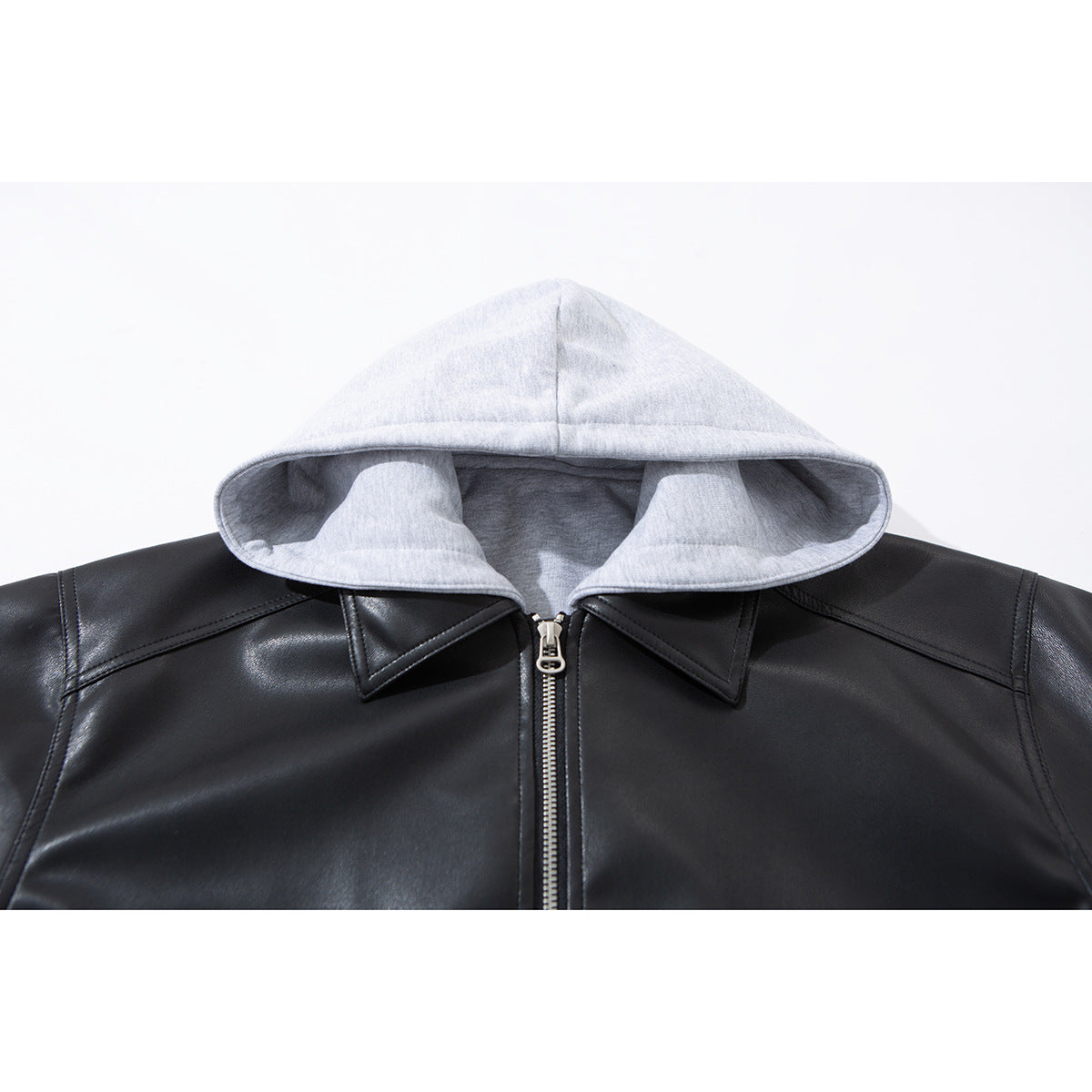 Close-up of a light gray hood and black jacket collar with a centered silver zipper.