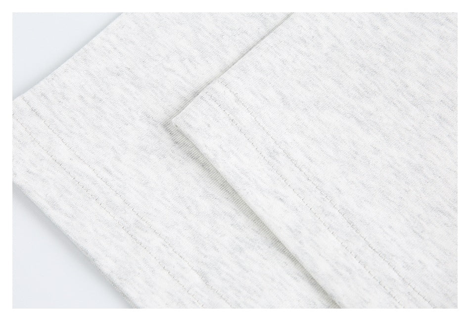 Close-up of light heather gray garment fabric with a curved stitched seam.
