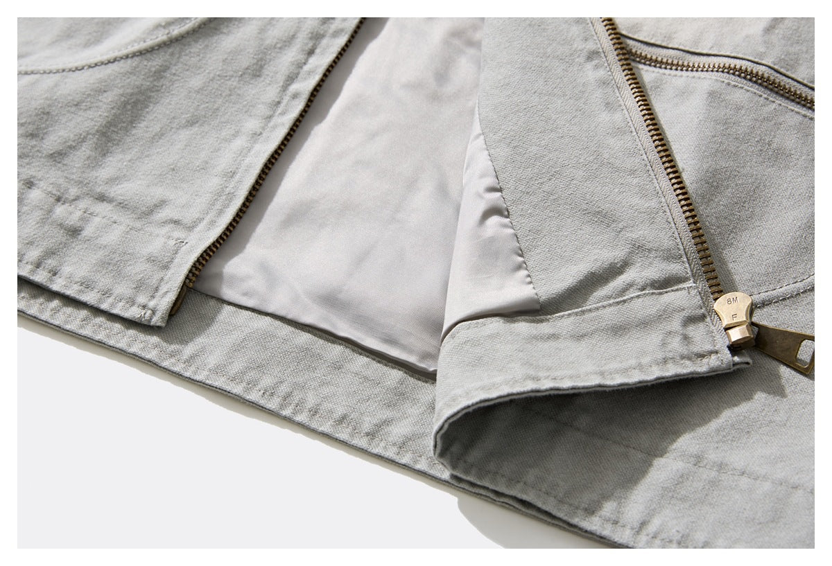 Light gray jacket opened to show its pale lining and brass front zipper.