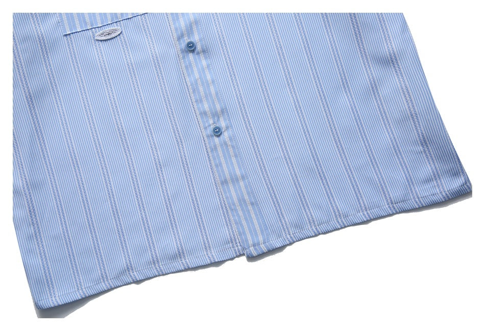 Close-up of the lower front and hem of a light blue striped button-up shirt.