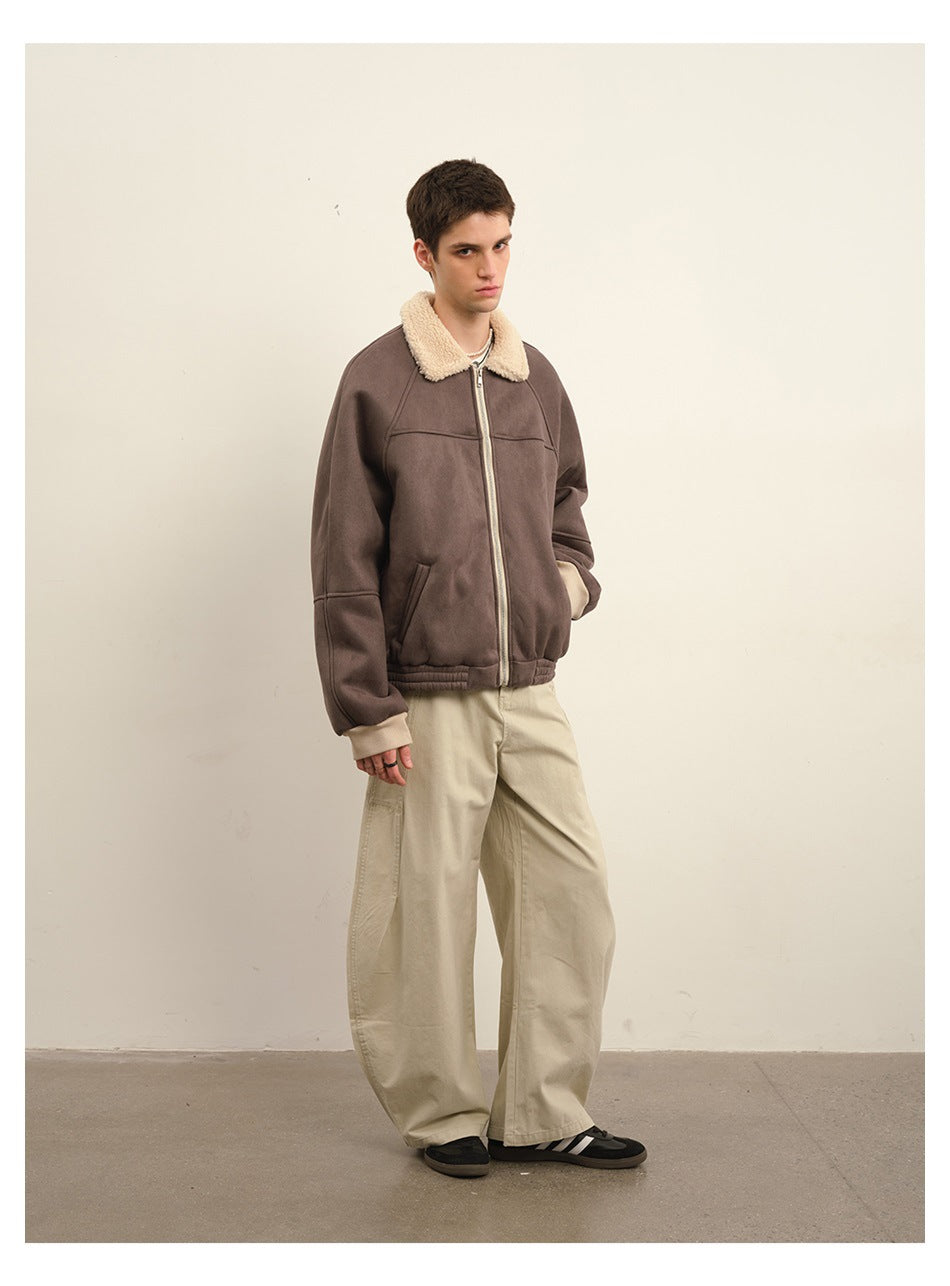 Model wearing a brown zip jacket with a cream plush collar and loose beige trousers, shown in a three-quarter view.