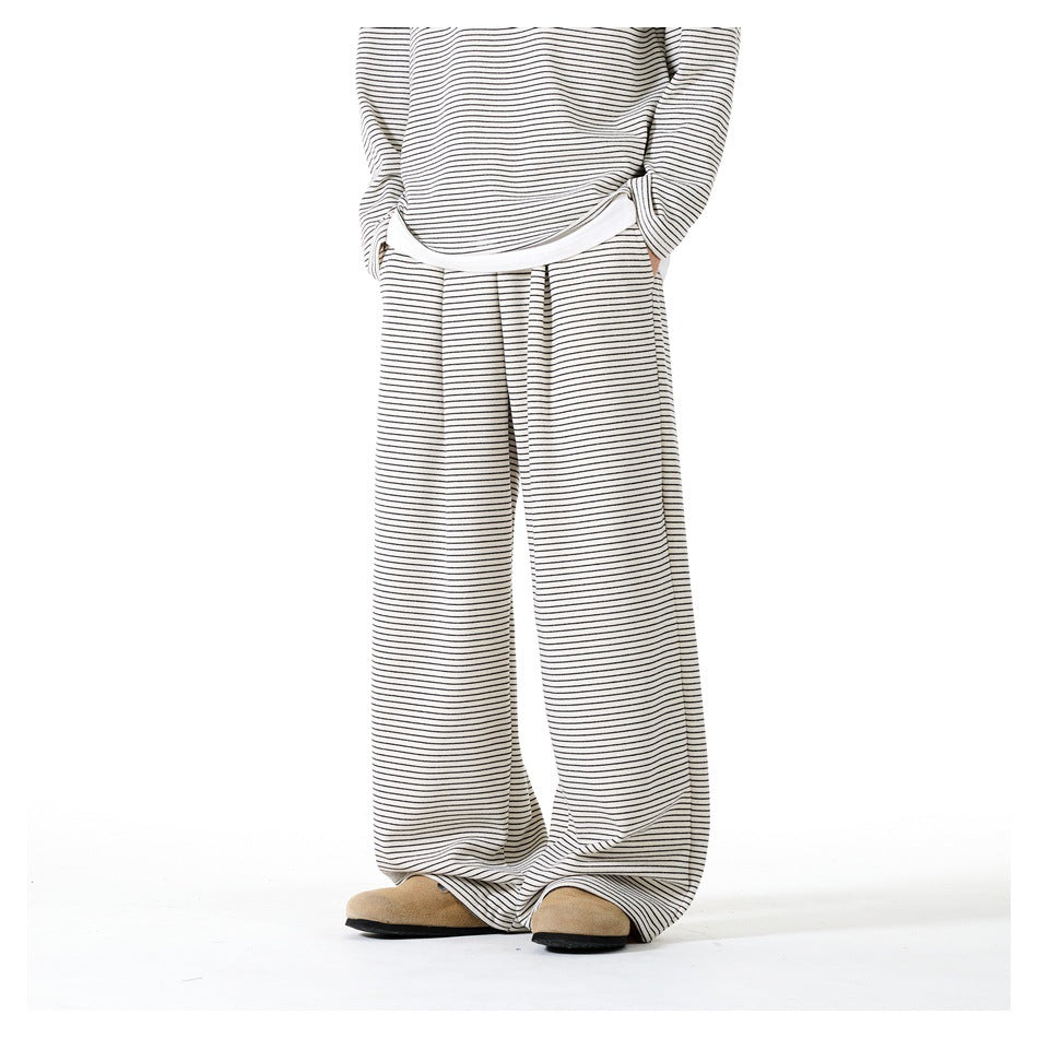 Angled view of beige striped wide-leg pants worn with matching striped top and tan suede clogs