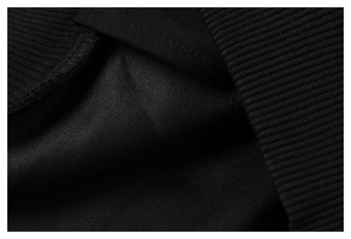 Close-up of black fabric showing a smooth panel beside a ribbed knit edge.