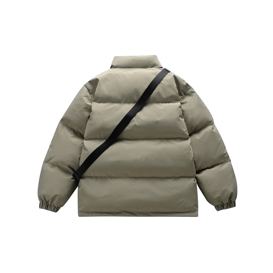 Back view of a gray-green quilted puffer jacket with a black crossbody strap and elastic cuffs.