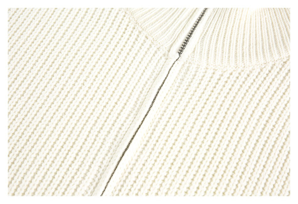 Close-up of the metal zipper and textured cream knit fabric.
