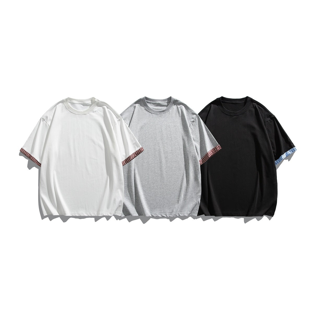 Three plain short-sleeve crew-neck T-shirts in white, gray, and black with plaid sleeve-edge trim.
