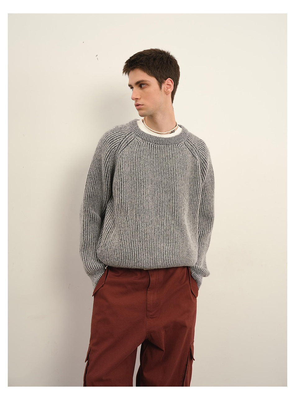 Male model wearing a gray ribbed crewneck sweater and rust-red cargo pants, shown from mid-thigh up.