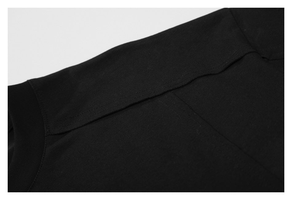 Close-up of the black T-shirt's shoulder seam and sleeve construction.