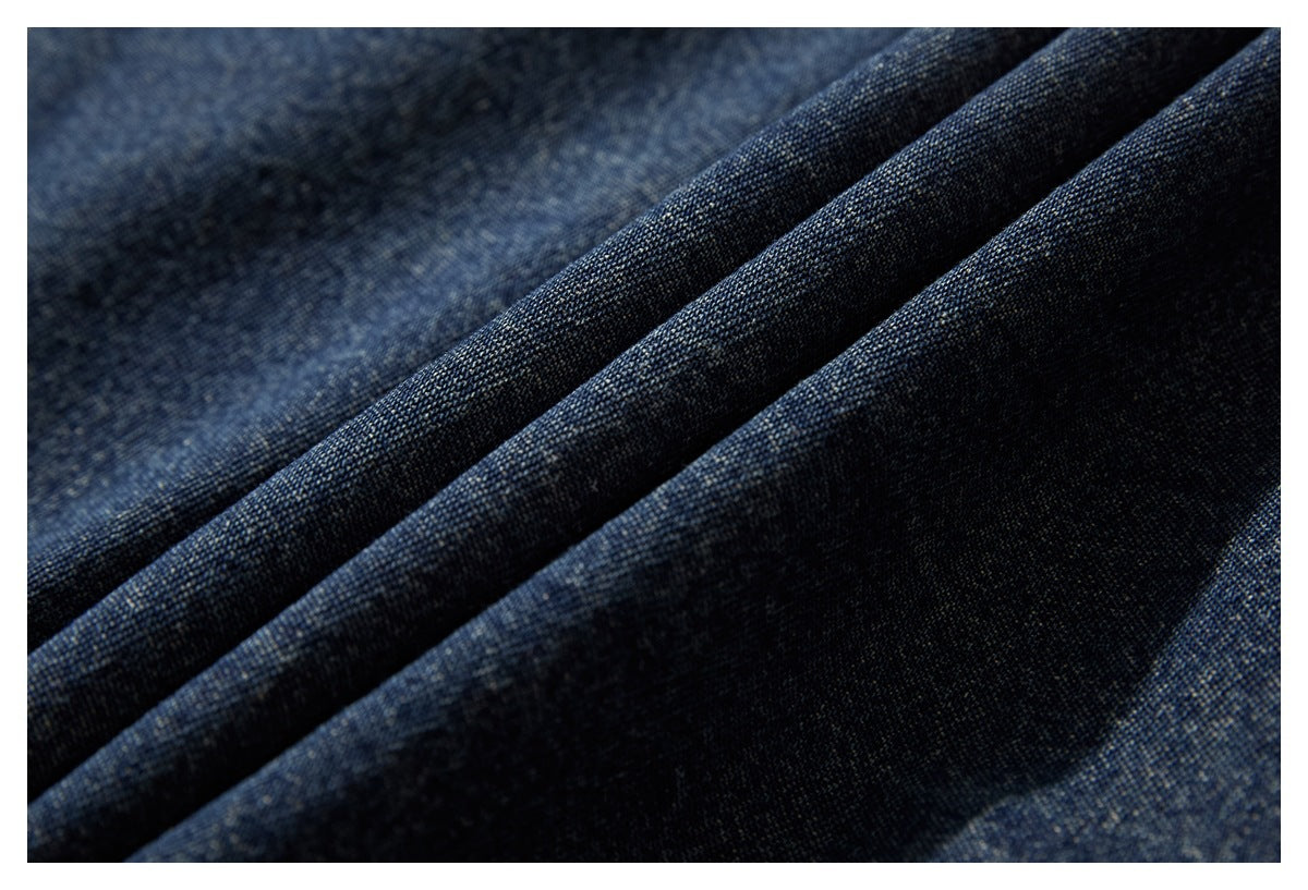 Macro view of dark indigo denim fabric arranged in soft folds.