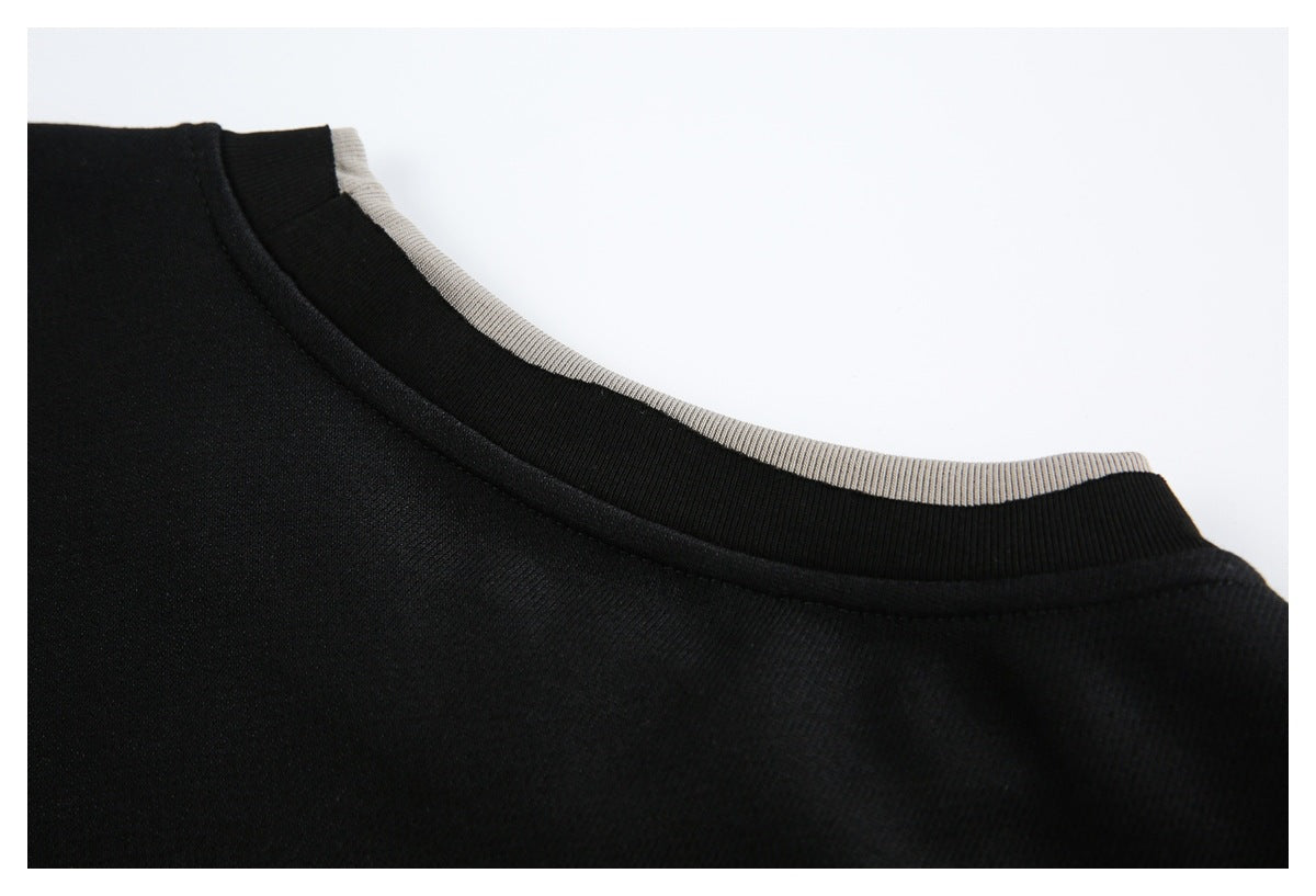 Close-up of a black crew neckline with a narrow light gray ribbed trim.