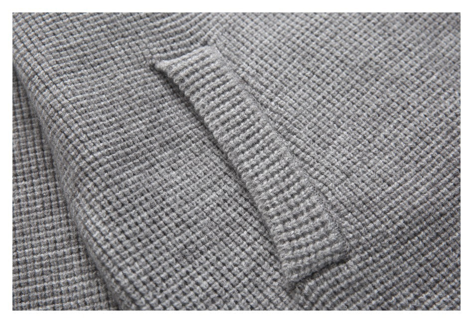 Close-up of a slanted pocket opening on a gray textured knit cardigan.