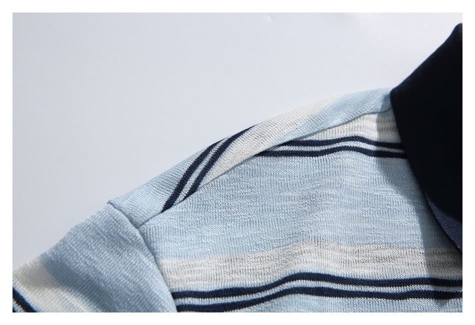 Close-up of the polo's striped shoulder seam and pale blue knit fabric.