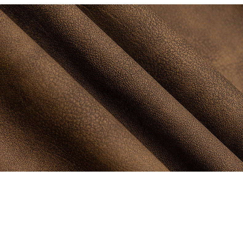 Extreme close-up showing the brown garment's pebbled surface texture and folded seam.