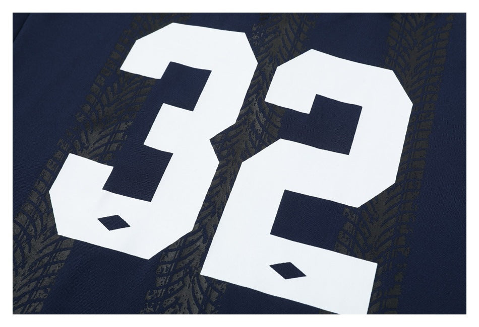 Close-up of a large white number 32 on navy fabric with a dark patterned design.
